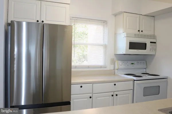 a kitchen with stainless steel appliances a refrigerator sink and cabinets