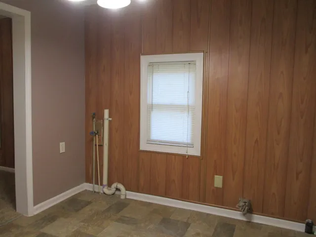 a sink with white cabinets and a window