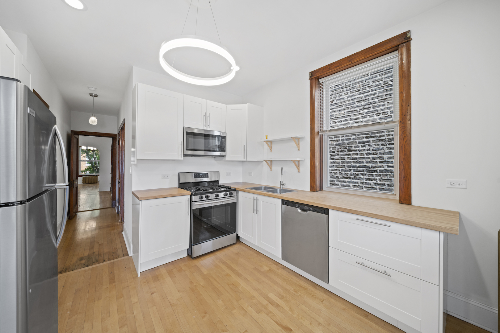 2545 West Walton Street, Unit 2 Chicago, IL 60622 - Photo 6 of 20 a kitchen with granite countertop a stove a sink and a refrigerator