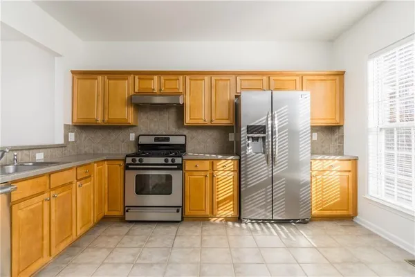 a kitchen with a refrigerator and a stove