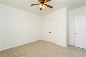 an empty room with a ceiling fan and a window