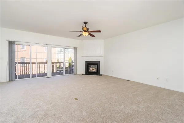 a view of an empty room with a fireplace and a window