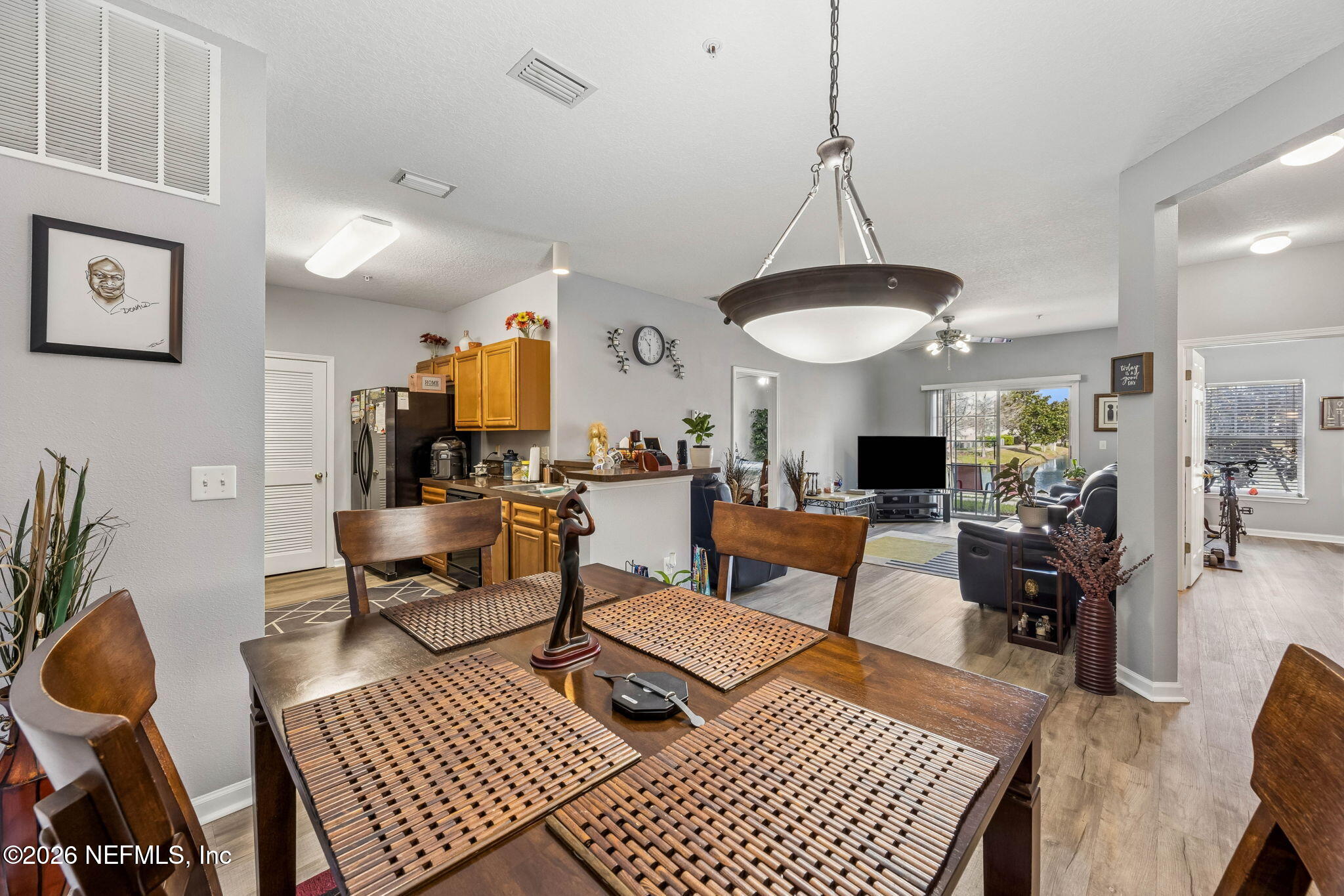 8215 Green Parrot Road, Unit 106 Jacksonville, FL 32256 - Photo 11 of 76 a living room with furniture a rug and a chandelier