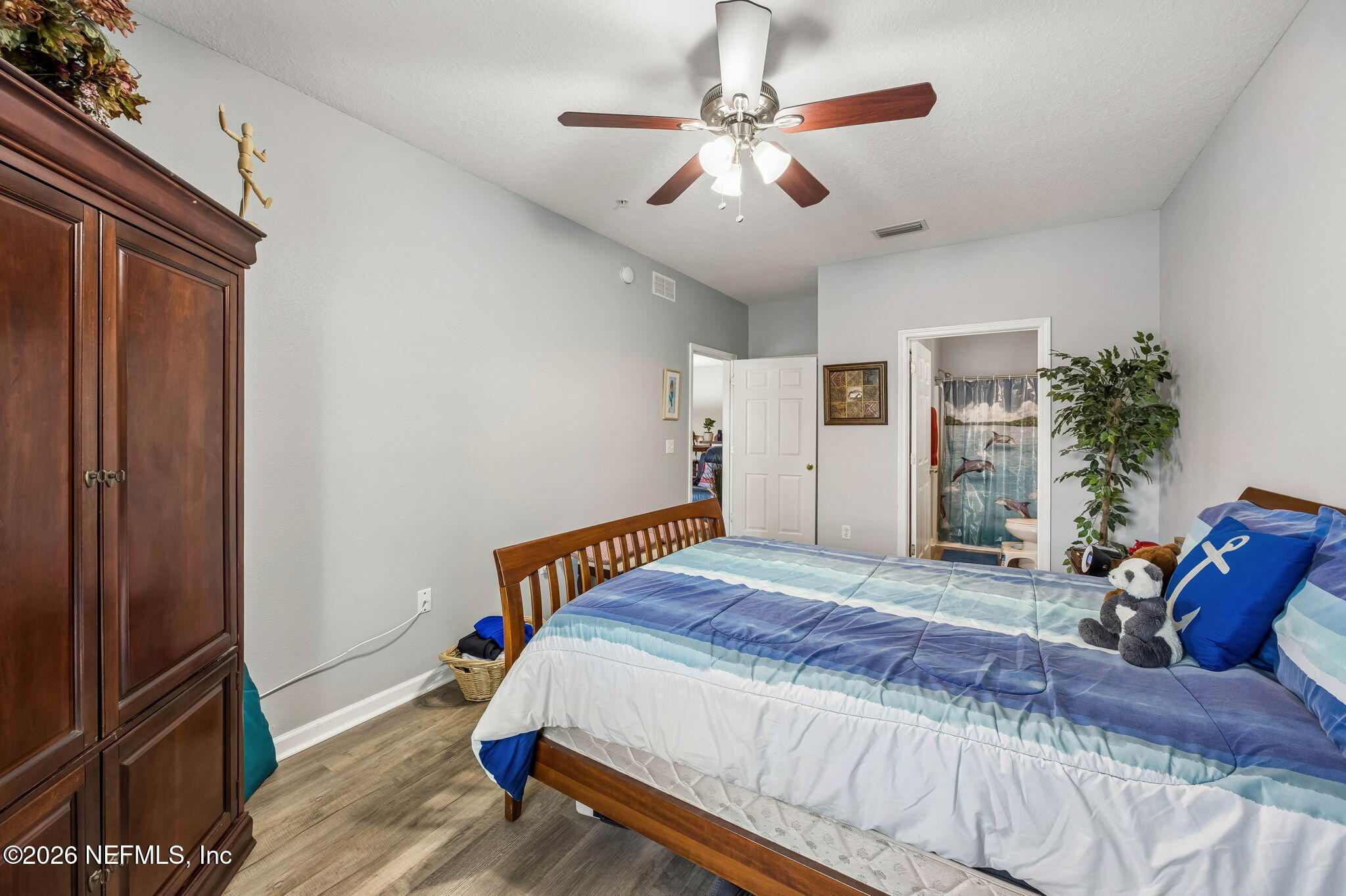 8215 Green Parrot Road, Unit 106 Jacksonville, FL 32256 - Photo 17 of 76 a bedroom with a bed and a chandelier