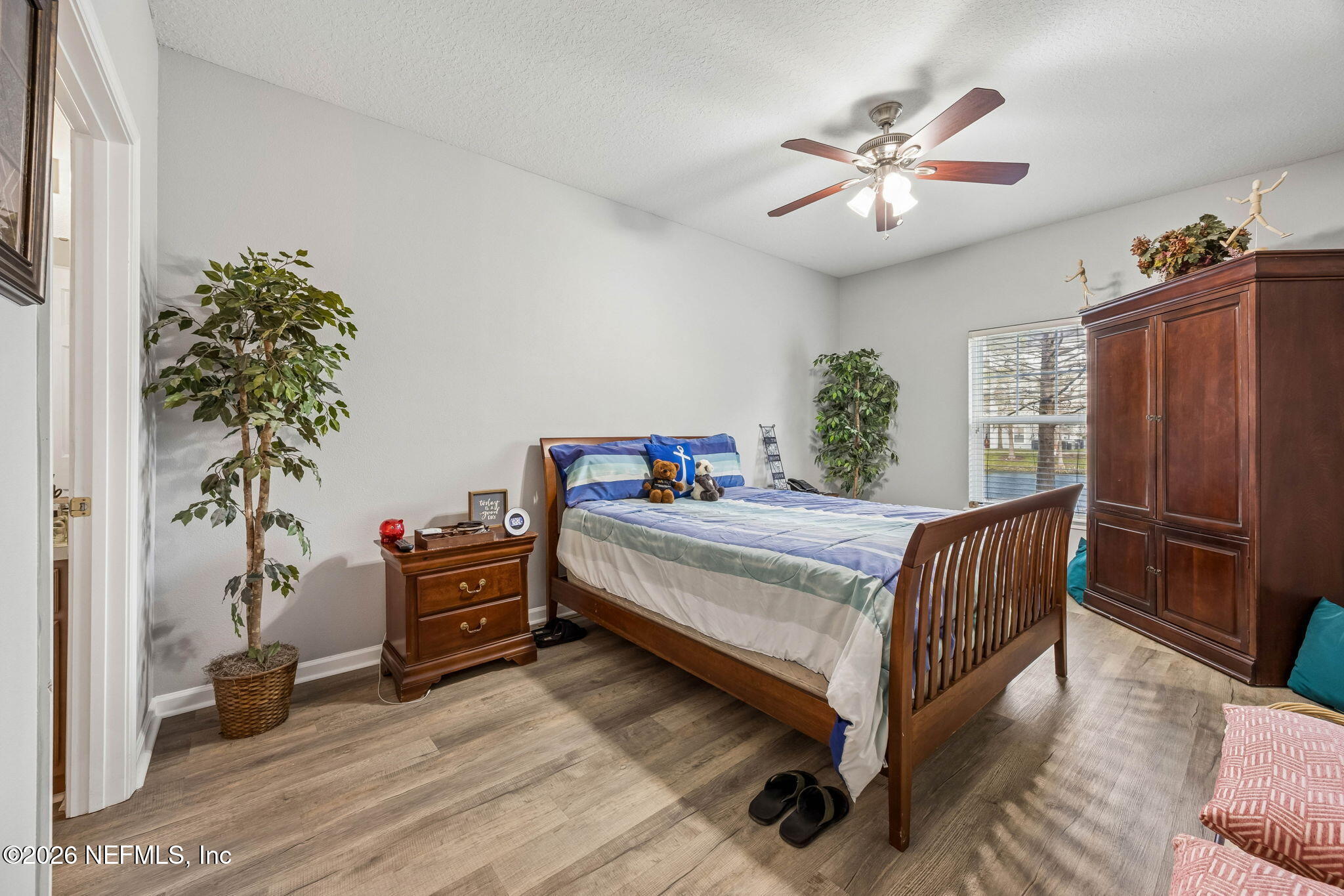 8215 Green Parrot Road, Unit 106 Jacksonville, FL 32256 - Photo 20 of 76 a bedroom with a bed and a chandelier