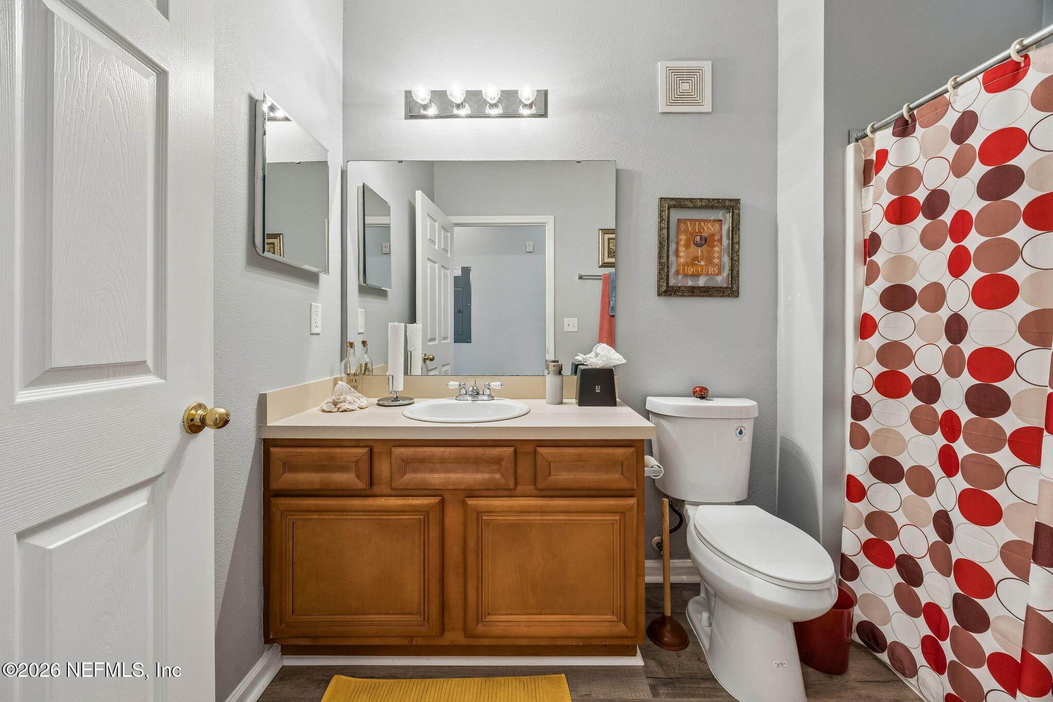 8215 Green Parrot Road, Unit 106 Jacksonville, FL 32256 - Photo 27 of 76 a bathroom with a sink a toilet a mirror and shower curtain