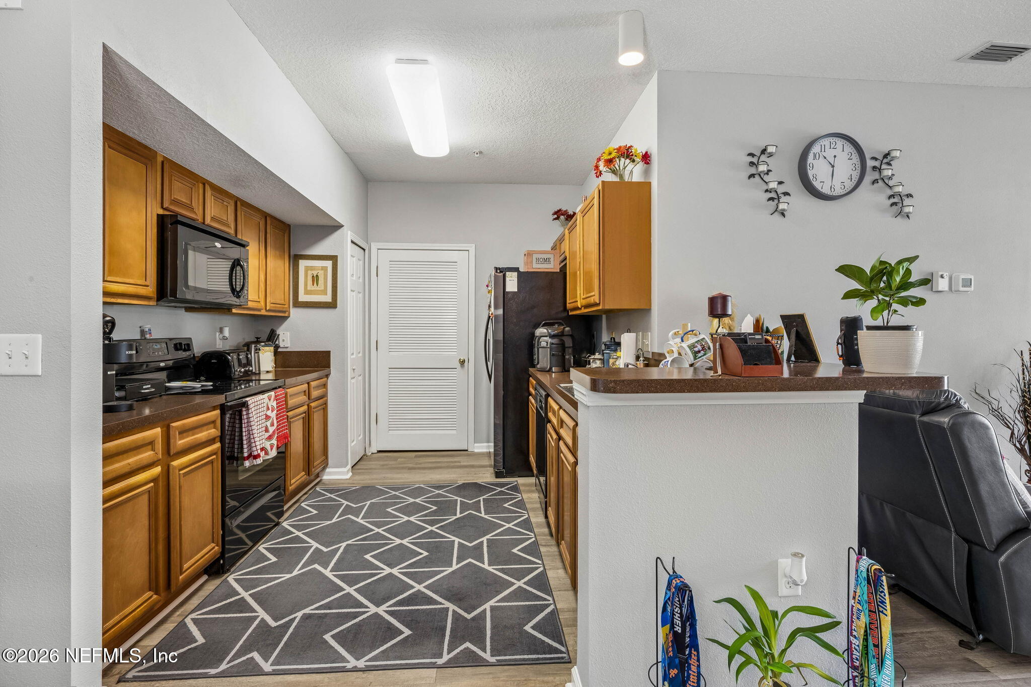 8215 Green Parrot Road, Unit 106 Jacksonville, FL 32256 - Photo 6 of 76 a kitchen with stainless steel appliances granite countertop a refrigerator and a stove top oven