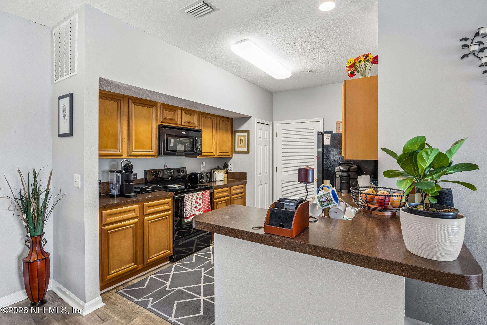 8215 Green Parrot Road, Unit 106 Jacksonville, FL 32256 - Photo 7 of 76 a kitchen with a sink a counter appliances and cabinets