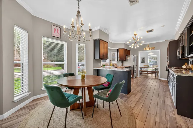 a dining room with furniture a chandelier and wooden floor