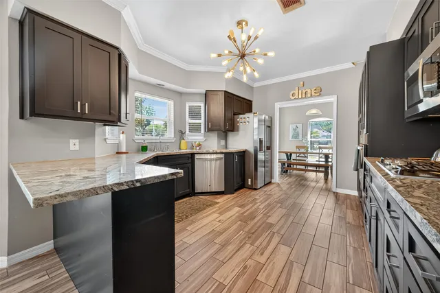 a kitchen with stainless steel appliances granite countertop a sink stove and refrigerator