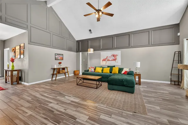 a living room with furniture and a wooden floor