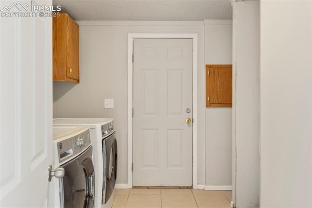 34535 Big Springs Road Yoder, CO 80864 - Photo 17 of 34 Washroom featuring independent washer and dryer, light tile patterned floors, cabinet space, and a textured ceiling