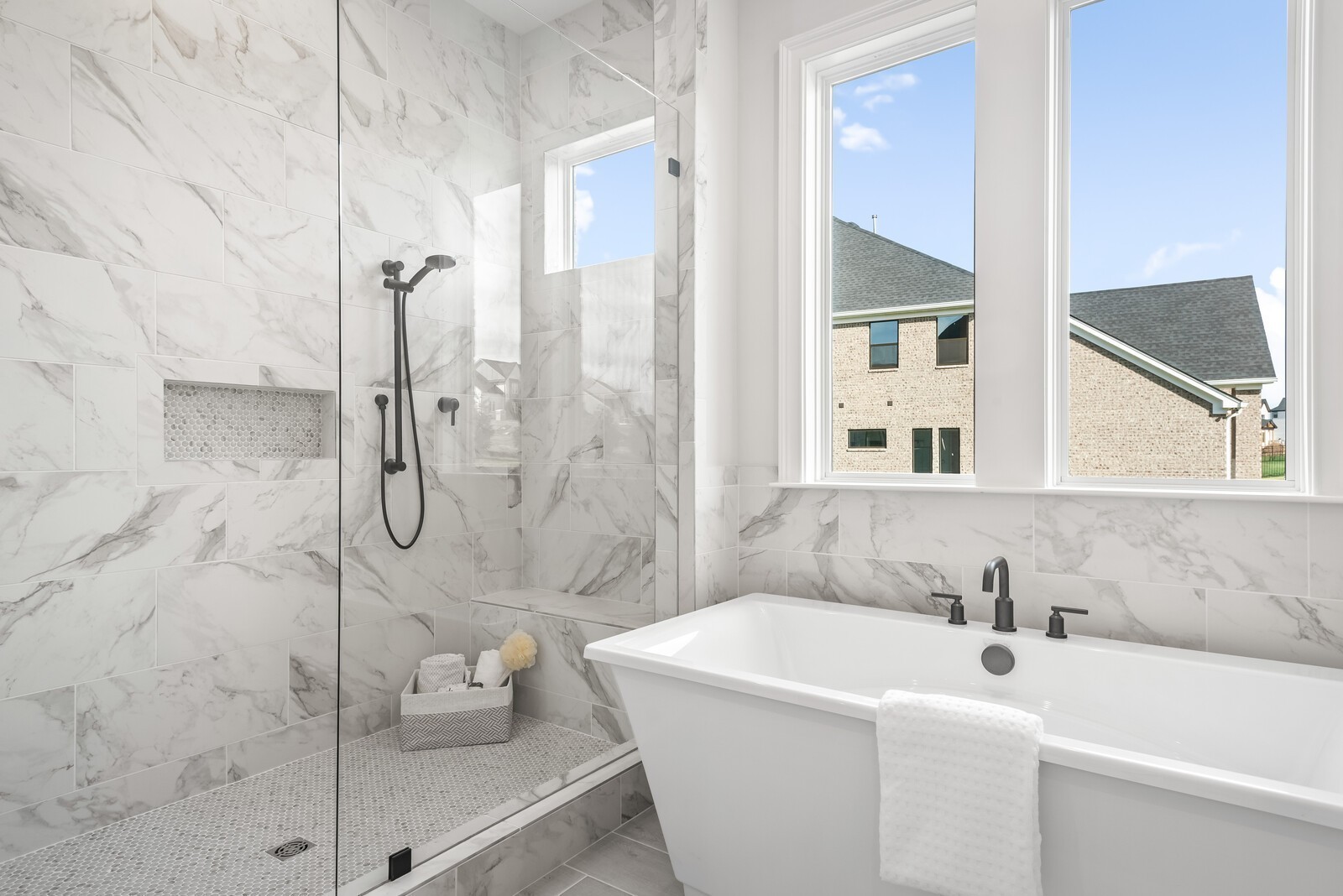 7265 Ruzek Court Fairview, TN 37062 - Photo 42 of 60 a bathroom with a white bath tub sitting next to a white sink and glass door