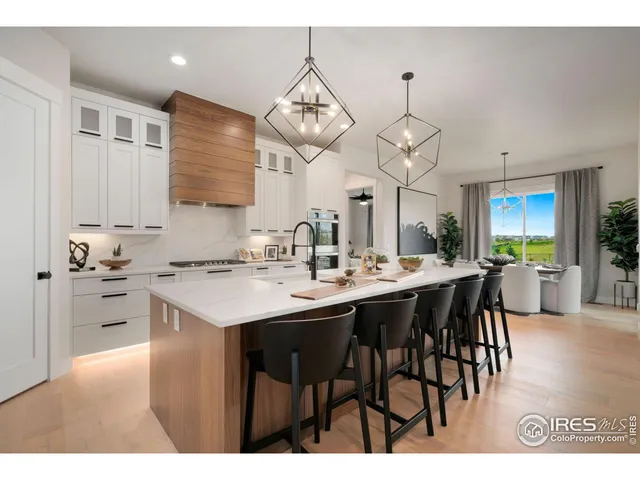 a kitchen with stainless steel appliances kitchen island granite countertop a sink table and chairs