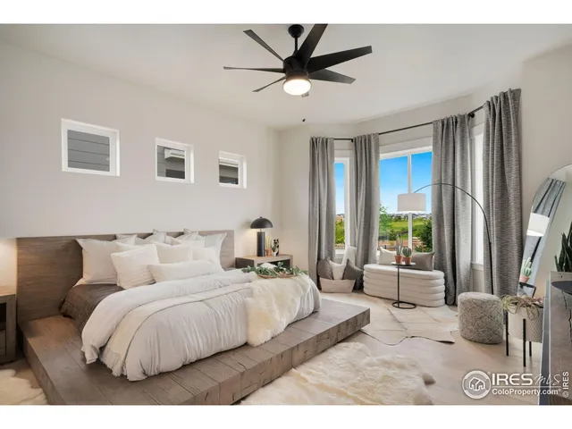 a bed room with a bed a couch and a ceiling fan