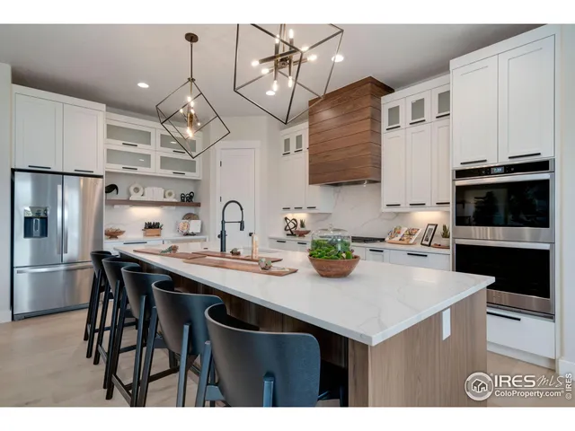 a kitchen with stainless steel appliances a sink a stove a refrigerator cabinets and dining table