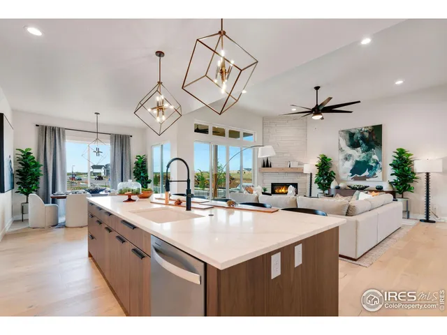 a kitchen with a sink a counter space appliances and living room view
