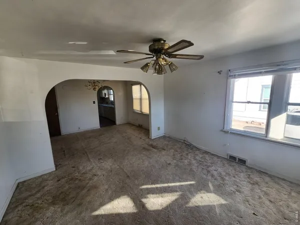 a view of a livingroom with a ceiling fan and window