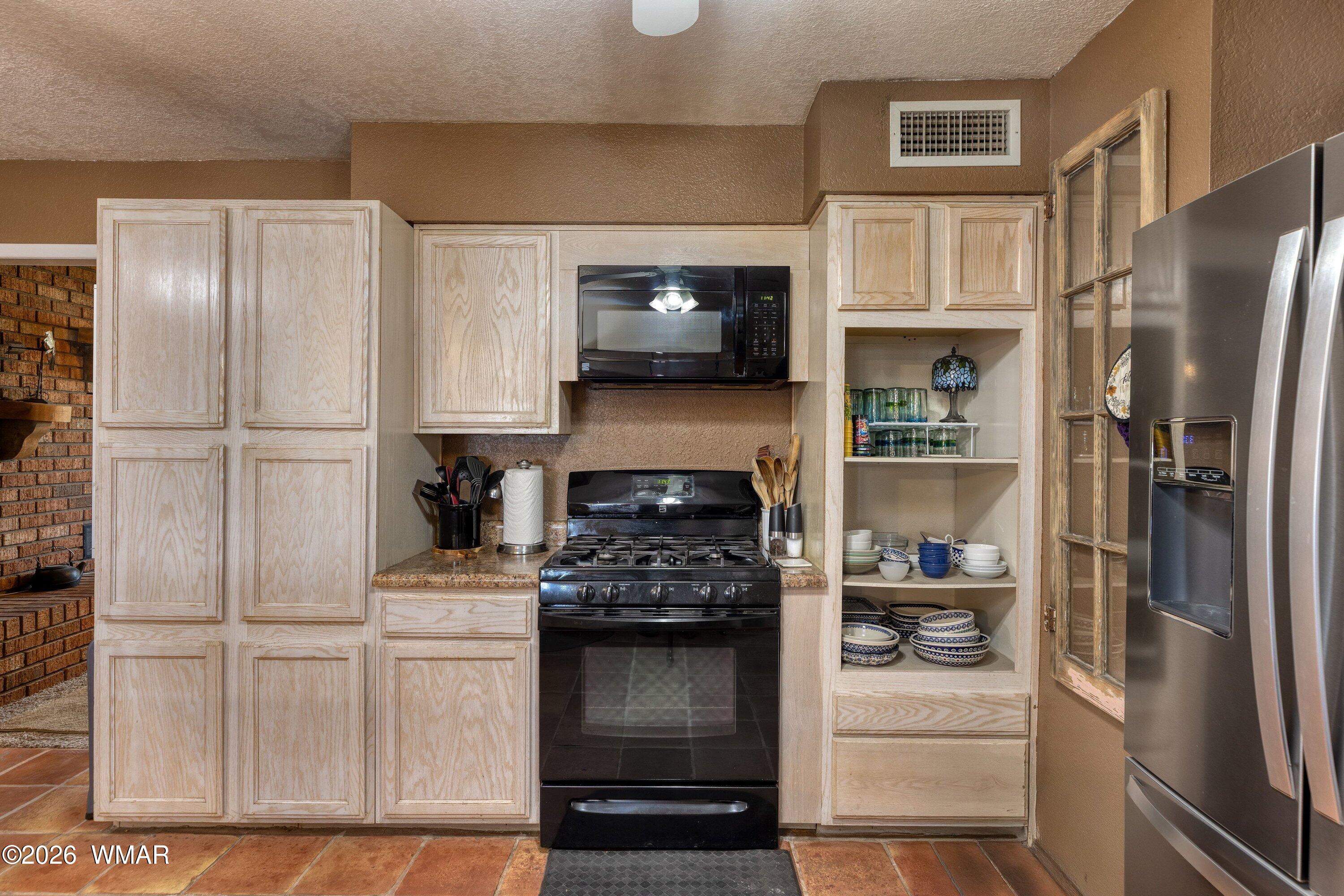 1114 Ranch Road Taylor, AZ 85939 - Photo 13 of 32 a kitchen with white cabinets and stainless steel appliances