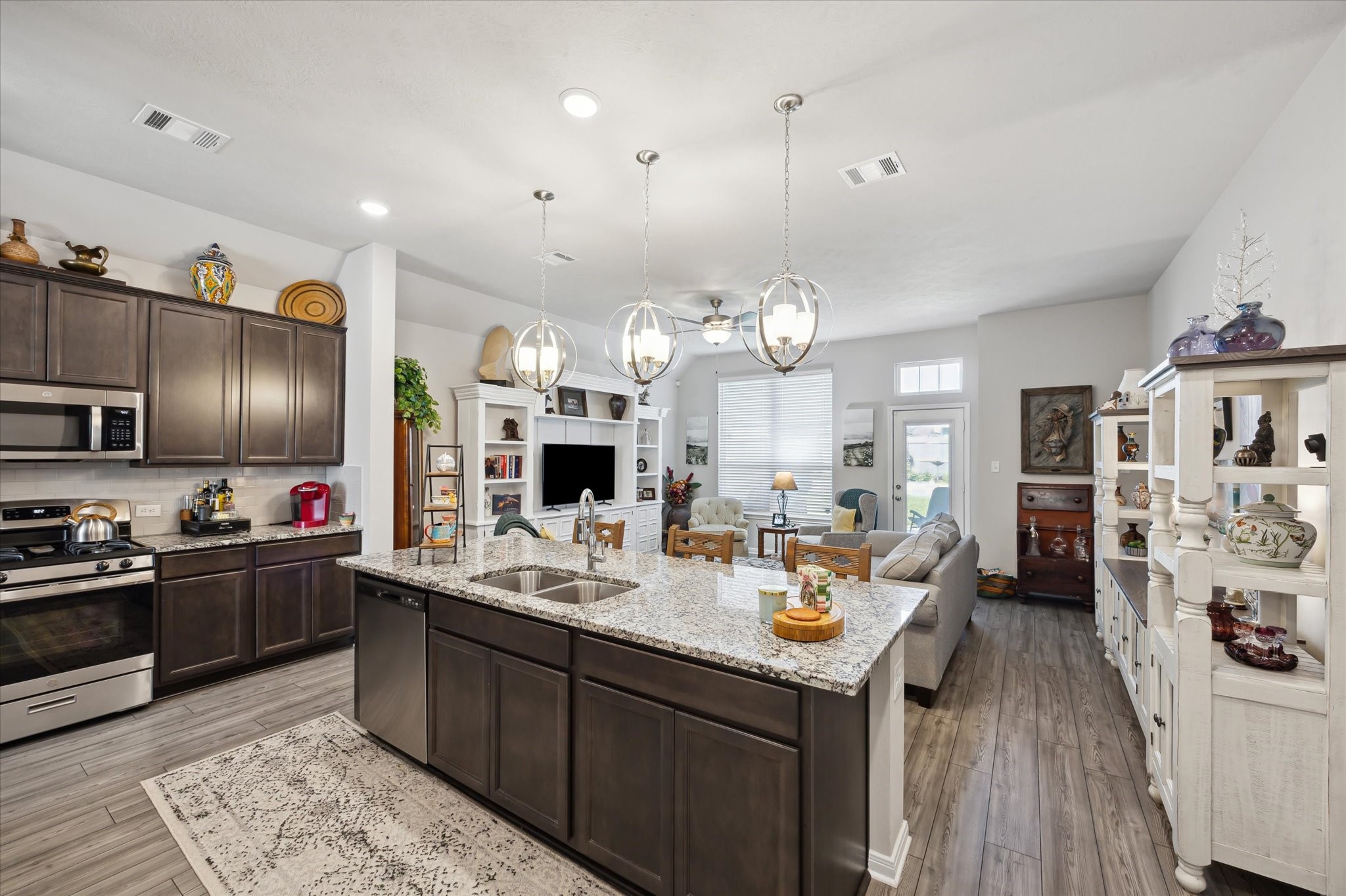 1010 Old Vine Road Brenham, TX 77833 - Photo 8 of 20 a large kitchen with kitchen island a refrigerator a stove a sink dishwasher a dining table and chairs with wooden floor