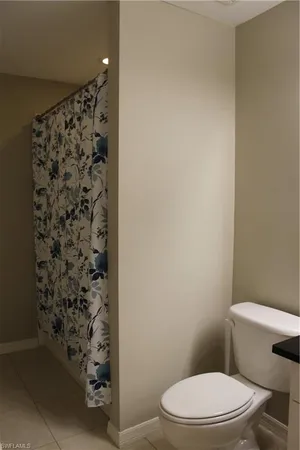 a white toilet sitting next to a shower curtain