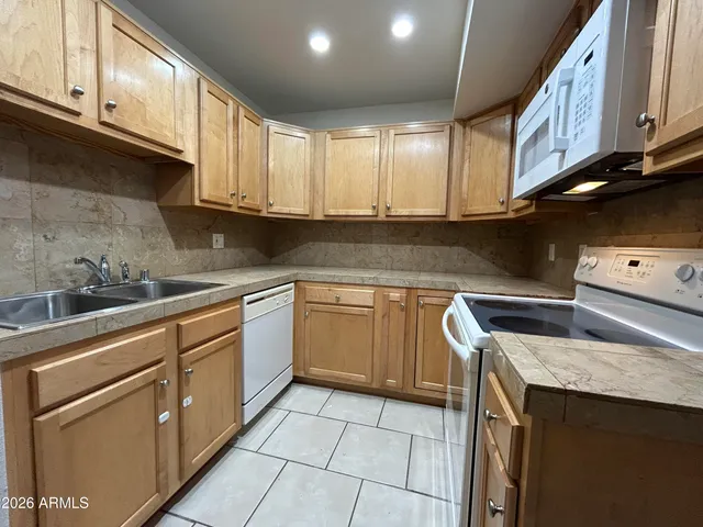 a kitchen with stainless steel appliances granite countertop white cabinets sink and dishwasher