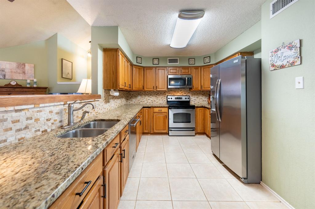 1611 Mission Ridge Trail Carrollton, TX 75007 - Photo 14 of 35 a kitchen with stainless steel appliances granite countertop a refrigerator a stove and a sink with cabinets