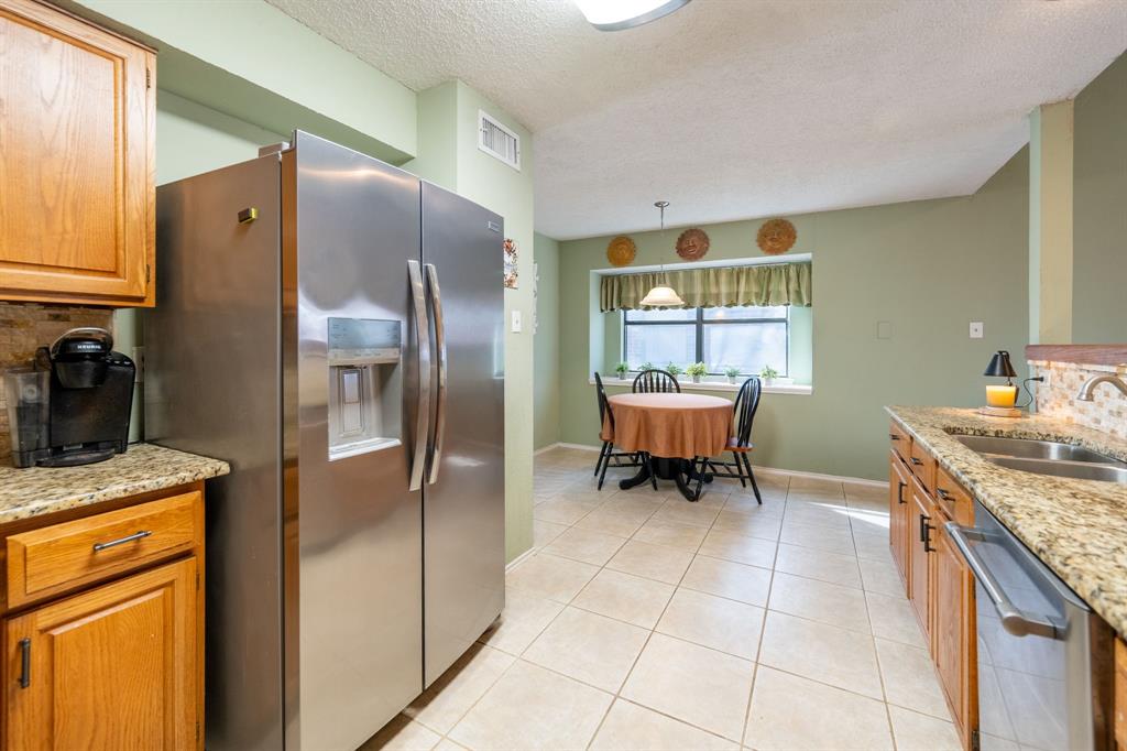 1611 Mission Ridge Trail Carrollton, TX 75007 - Photo 15 of 35 a kitchen with a stove a refrigerator and a cabinets