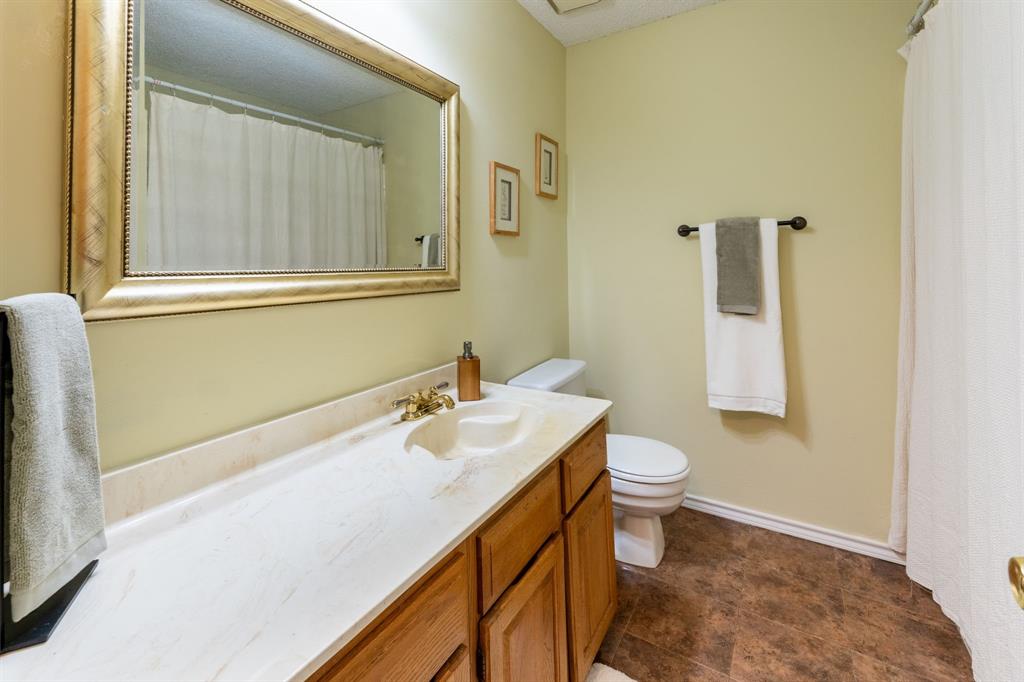 1611 Mission Ridge Trail Carrollton, TX 75007 - Photo 28 of 35 a bathroom with a sink a toilet and a mirror