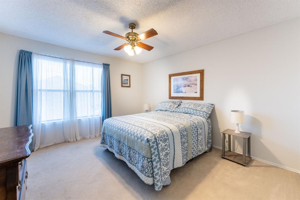 1611 Mission Ridge Trail Carrollton, TX 75007 - Photo 29 of 35 a spacious bedroom with a bed and a chandelier