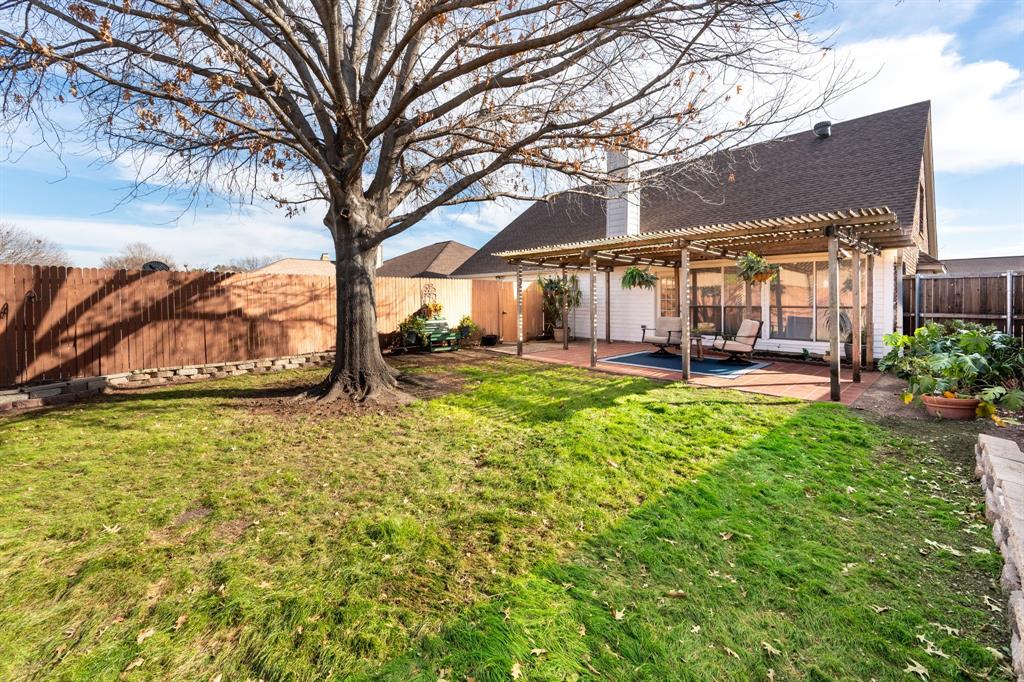 1611 Mission Ridge Trail Carrollton, TX 75007 - Photo 35 of 35 a backyard of a house with a garden and outdoor seating
