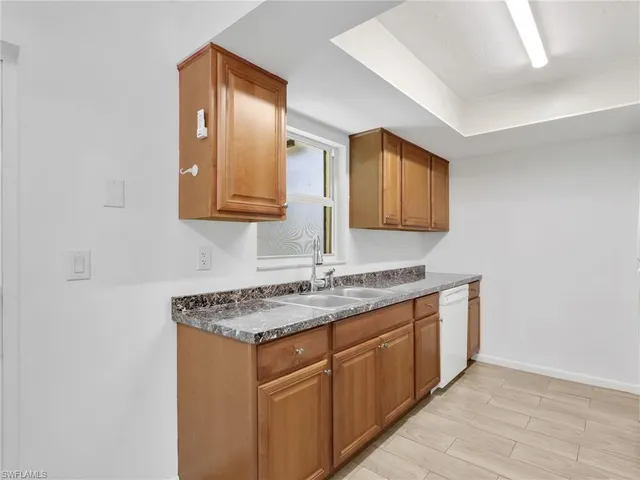 a bathroom with a granite countertop sink a mirror and cabinets