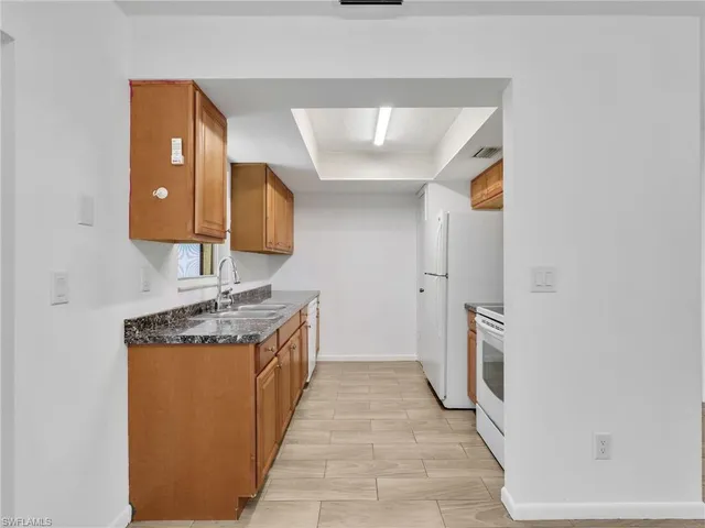 a en suite bathroom with a granite countertop sink and a mirror