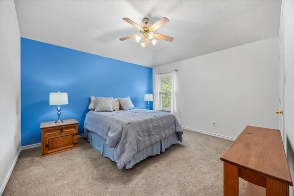 a spacious bedroom with a bed and a ceiling fan