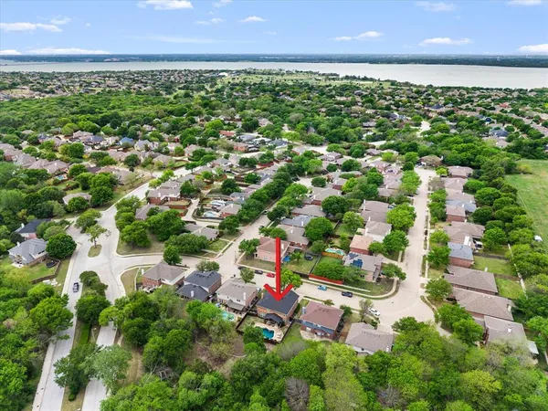 an aerial view of residential houses with outdoor space and trees