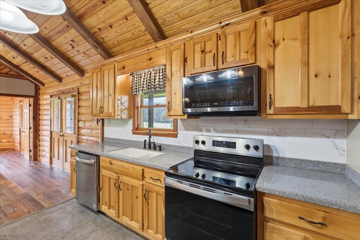 854 Holston Shores Drive Rutledge, TN 37861 - Photo 11 of 52 a kitchen with stainless steel appliances a stove a microwave and wooden cabinets