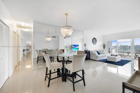 a view of a dining room and livingroom with furniture wooden floor a rug and a chandelier
