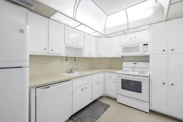 a kitchen with cabinets appliances sink and cabinets