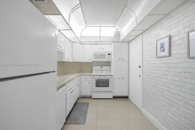 a kitchen with white cabinets and white appliances