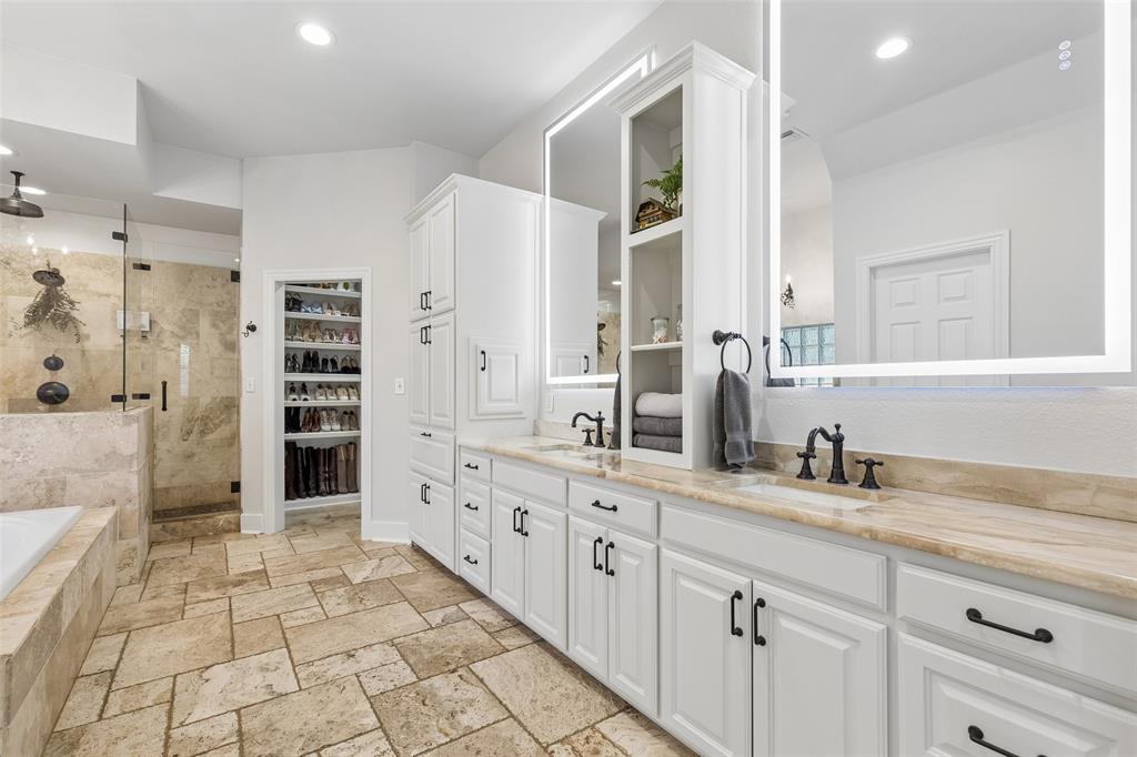 12630 Merrill Road Pilot Point, TX 76258 - Photo 14 of 39 Primary bath offers beautiful travertine floors, walk-in shower, deep soaking tub, custom closet system and dual sinks and marble vanities.