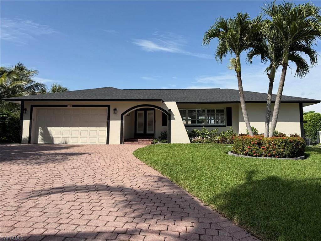 2140 Shad Court Naples, FL 34102 - Photo 6 of 44 front view of a house with a garden