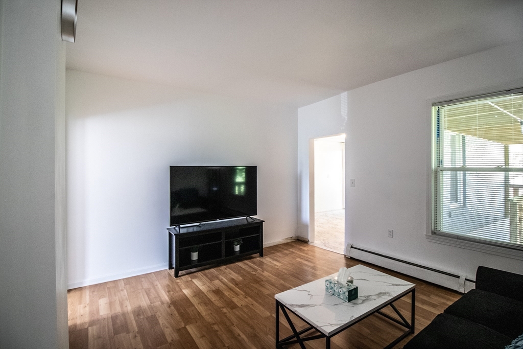 91 Elm Street Holyoke, MA 01040 - Photo 12 of 32 a living room with furniture and a flat screen tv