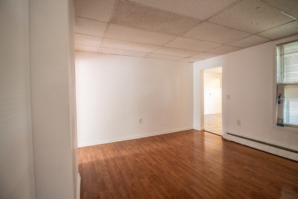 91 Elm Street Holyoke, MA 01040 - Photo 22 of 32 a view of an empty room with wooden floor and a window