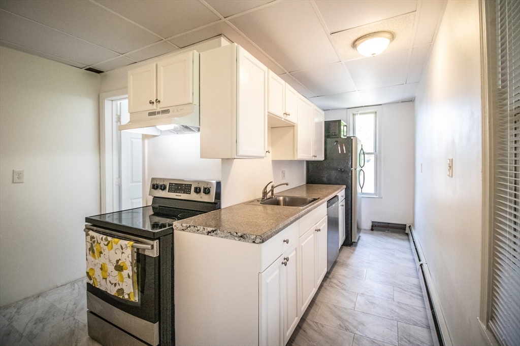 91 Elm Street Holyoke, MA 01040 - Photo 9 of 32 a kitchen with a stove a sink and a refrigerator