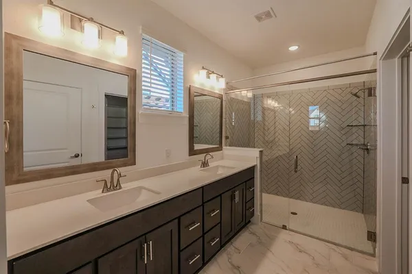 a bathroom with a double vanity sink mirror double and shower