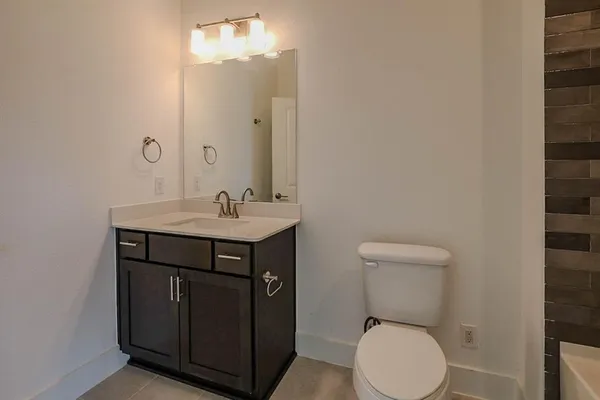 a bathroom with a toilet a sink and mirror