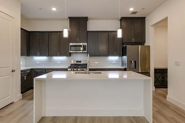 a kitchen with kitchen island stainless steel appliances a refrigerator sink and stove
