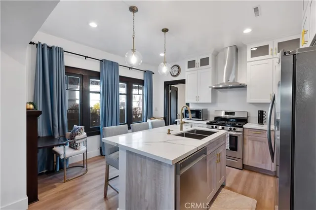 a kitchen that has a lot of cabinets a sink and appliances in it