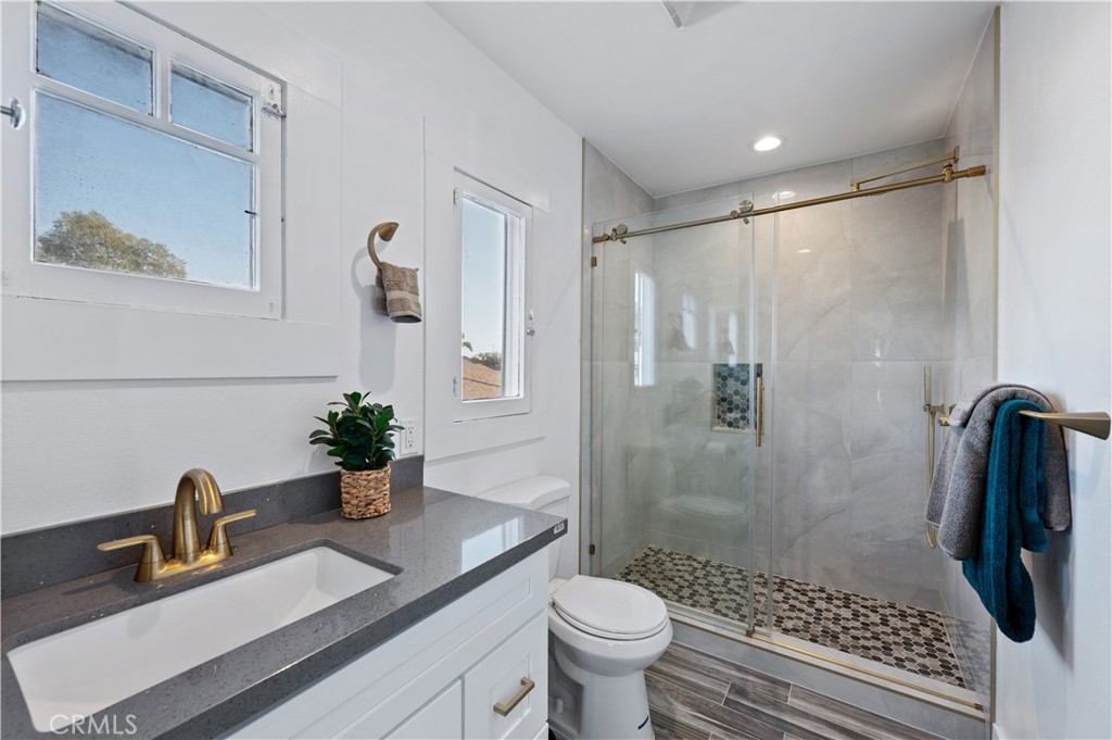 2920 East 7th Street Long Beach, CA 90814 - Photo 9 of 13 a bathroom with a sink toilet a mirror and shower