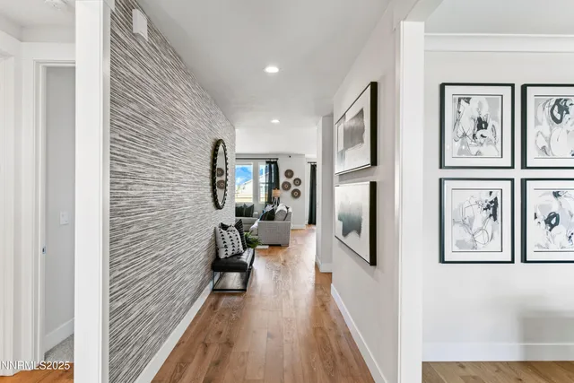 a view of a hallway with wooden floor and staircase